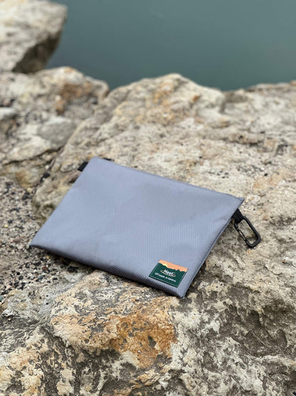 Heel™ weathproof storage case on rocks near water